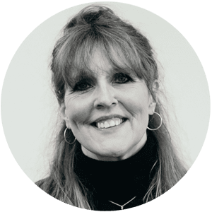 Alison Tickell, a woman with long fair hair and a fringe wearing a black polo neck smiling