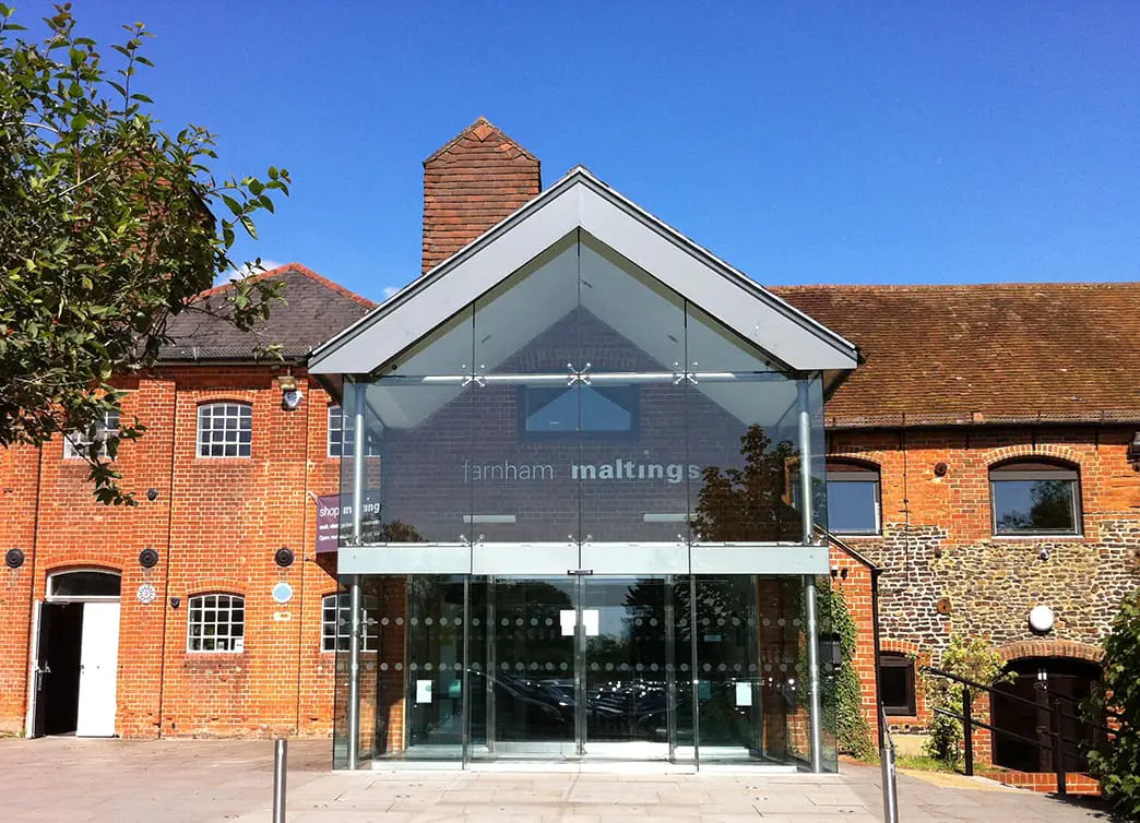 Building with glass windows and red brick exterior against a blue sky