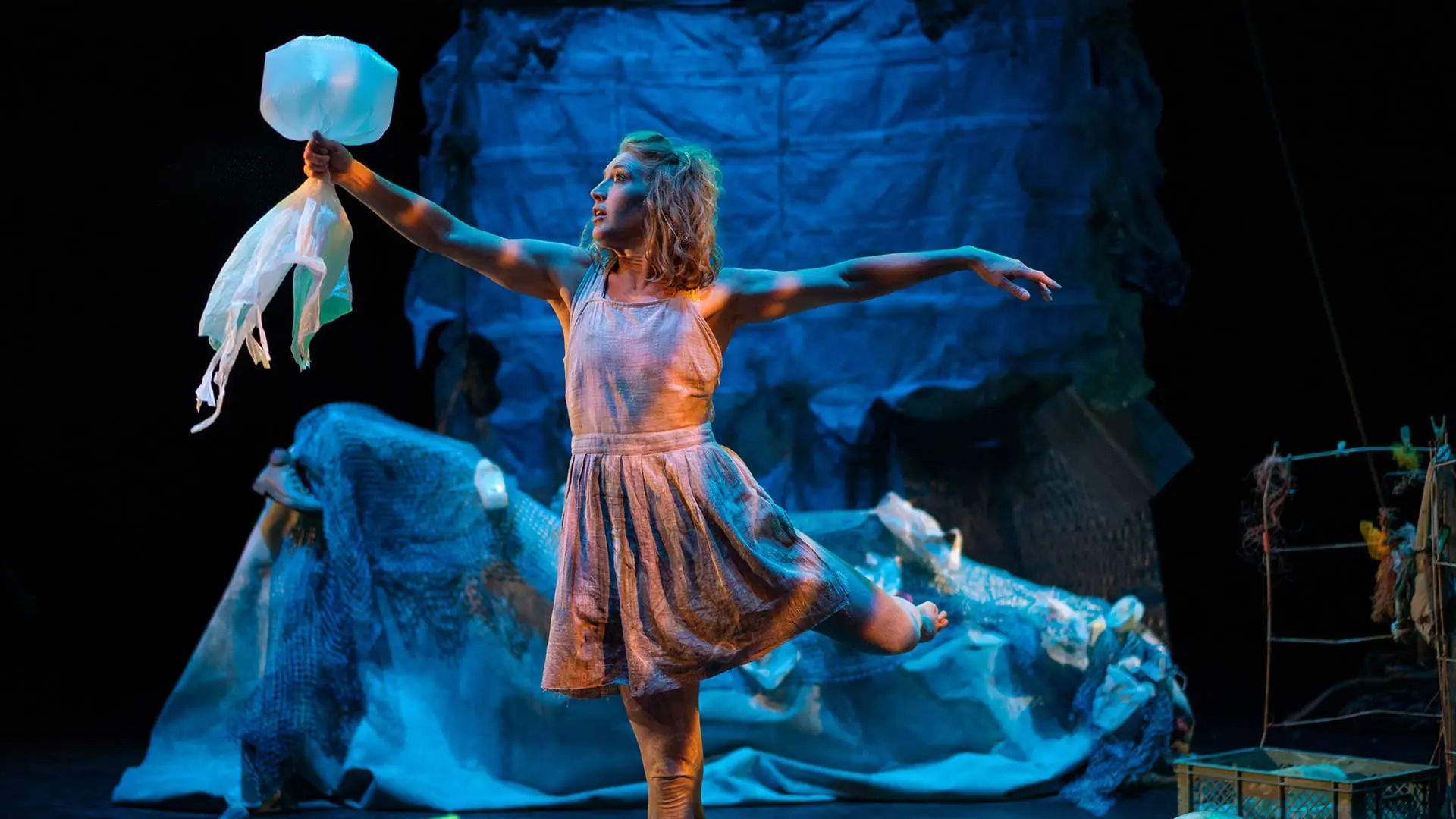 person holding fake jelly fish on stage, standing