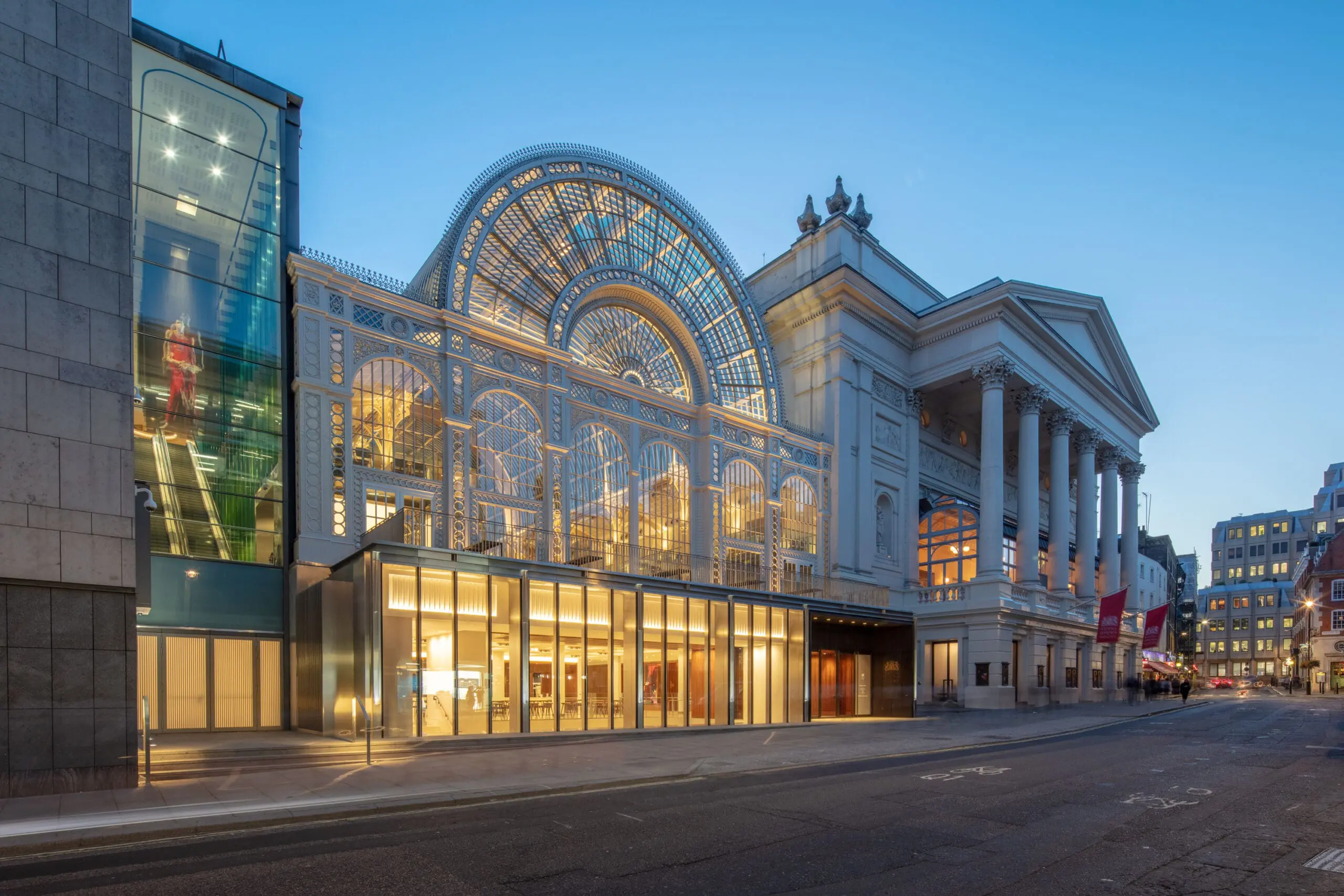 Glass fronted building at night with lights on inside
