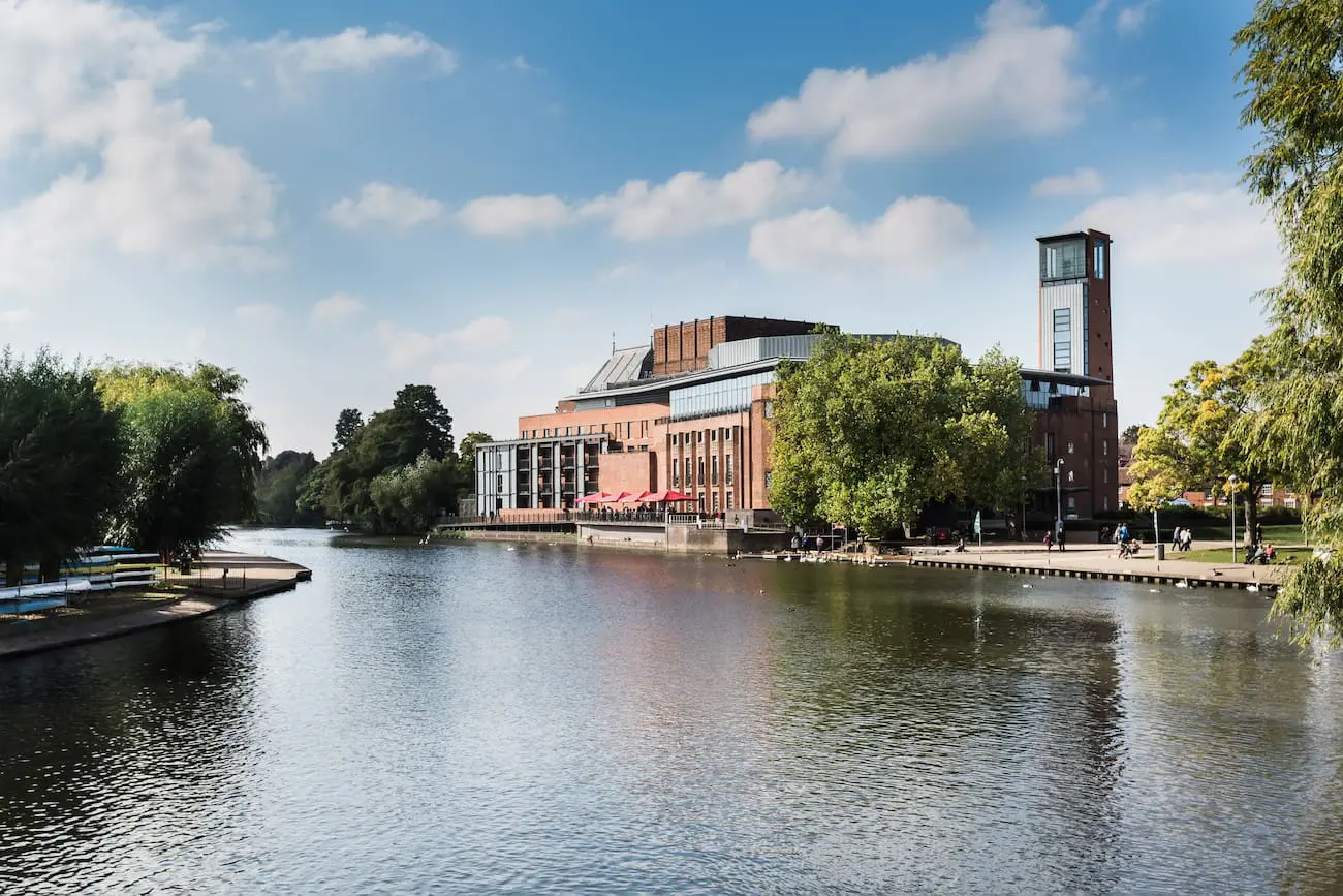 River in the foreground. A red brick building in the background against a blue sky