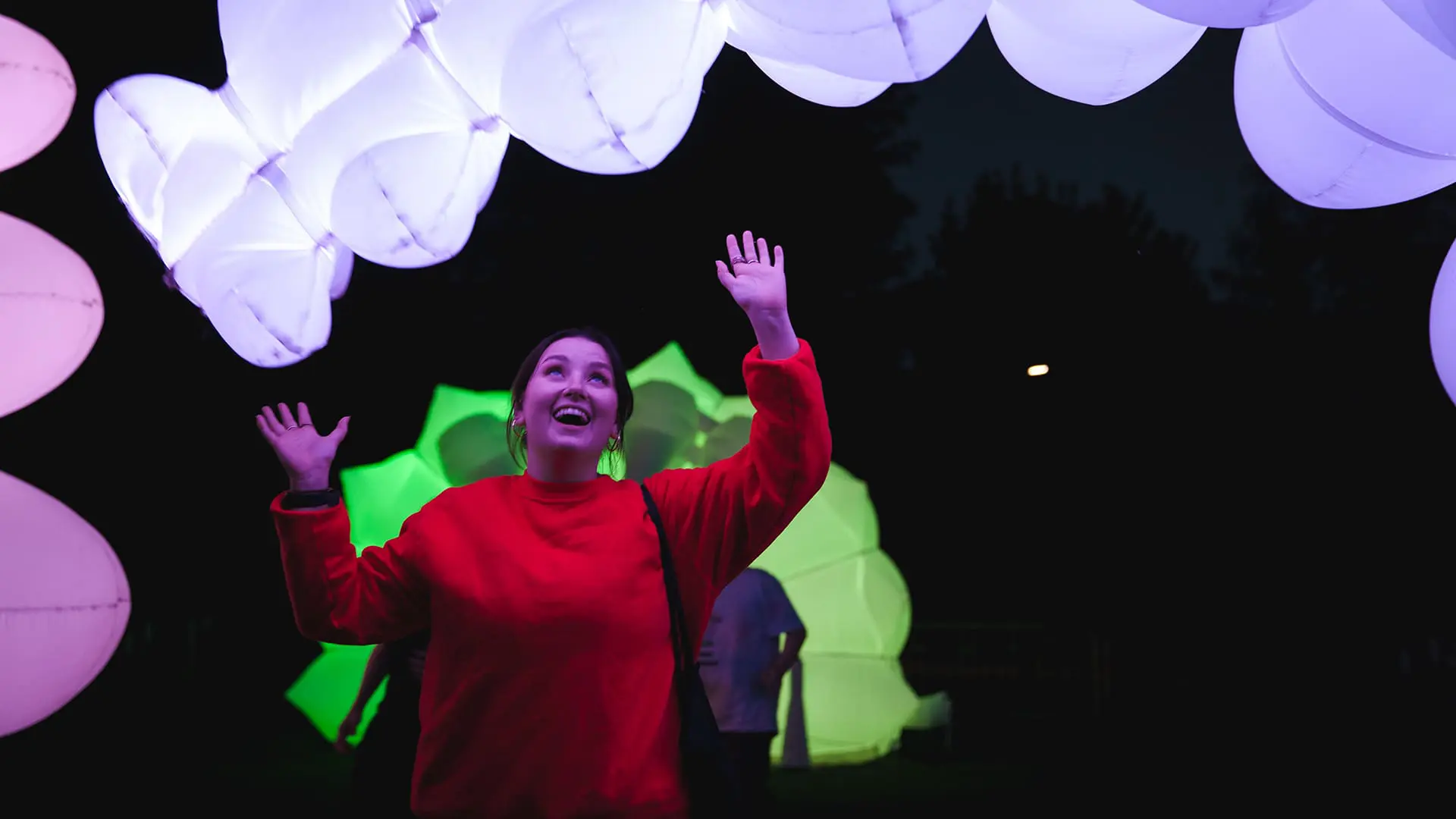Person outdoors overlooking bright light installation