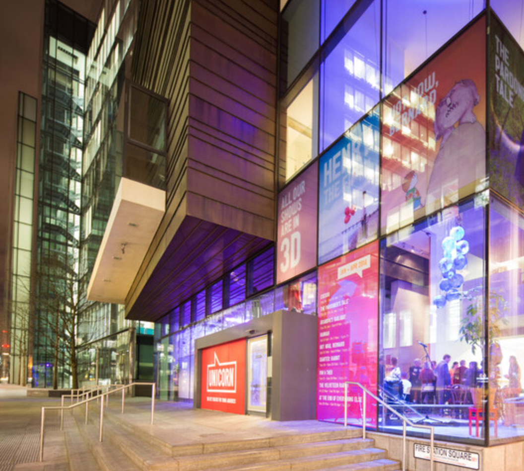 Close up of glass fronted building and colourful panels at night