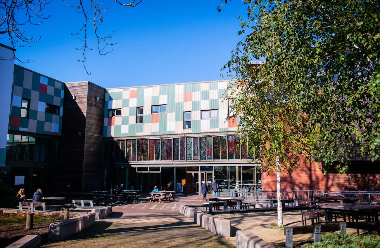 Building with glass windows and multi coloured exterior against a blue sky