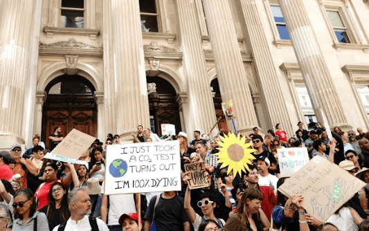 Photograph of environmental protestors in front of a historic building.