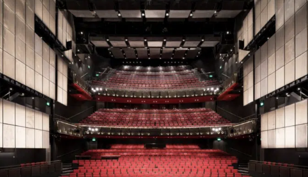 indoor auditorium with red seats and lights