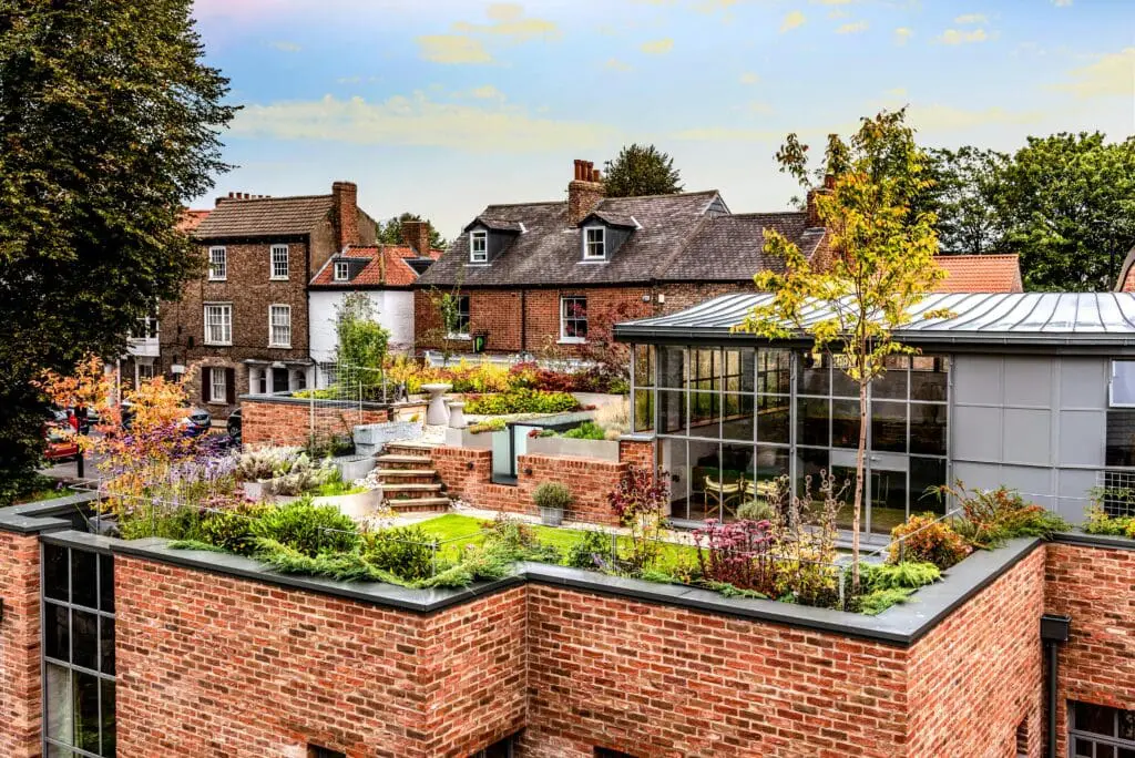 A beautiful rooftop garden on red-brick buildings under a clear sky