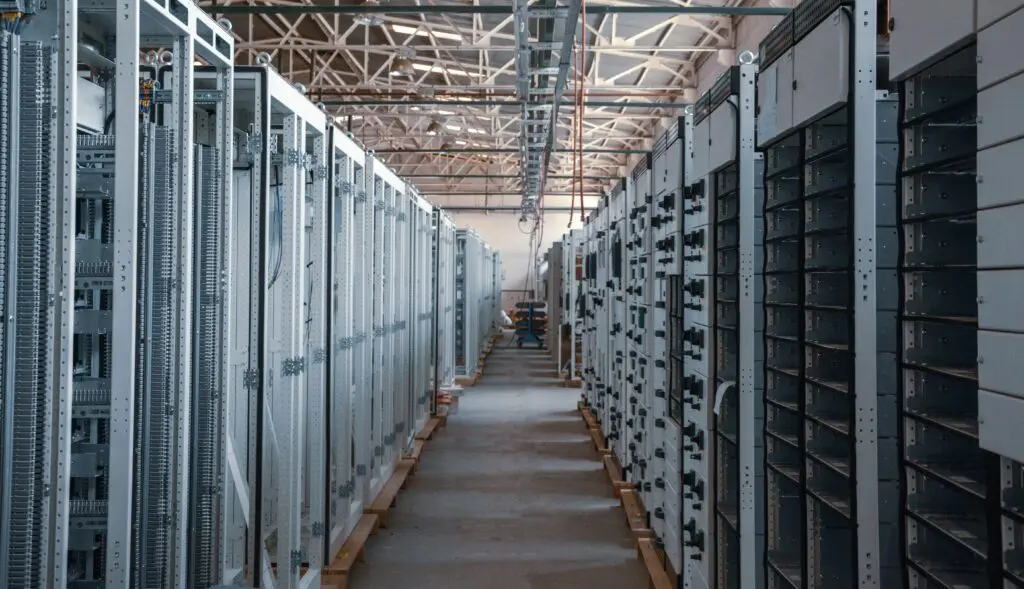 A data centre with a huge long row of data computers in glass cases