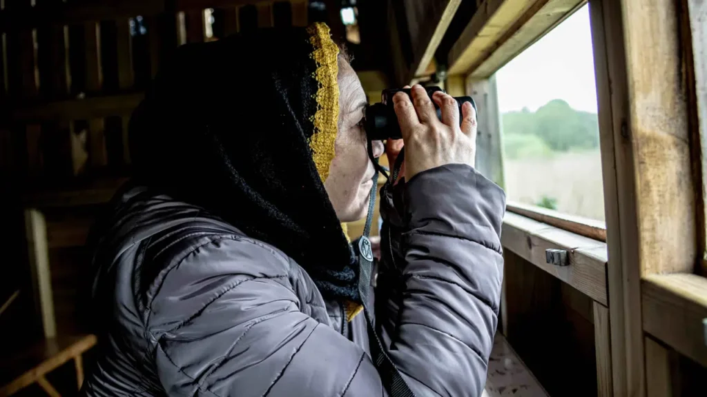 person looking through binoculars